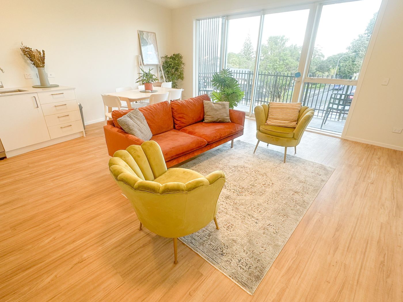 Living room with sofa and armchairs, balcony beyond