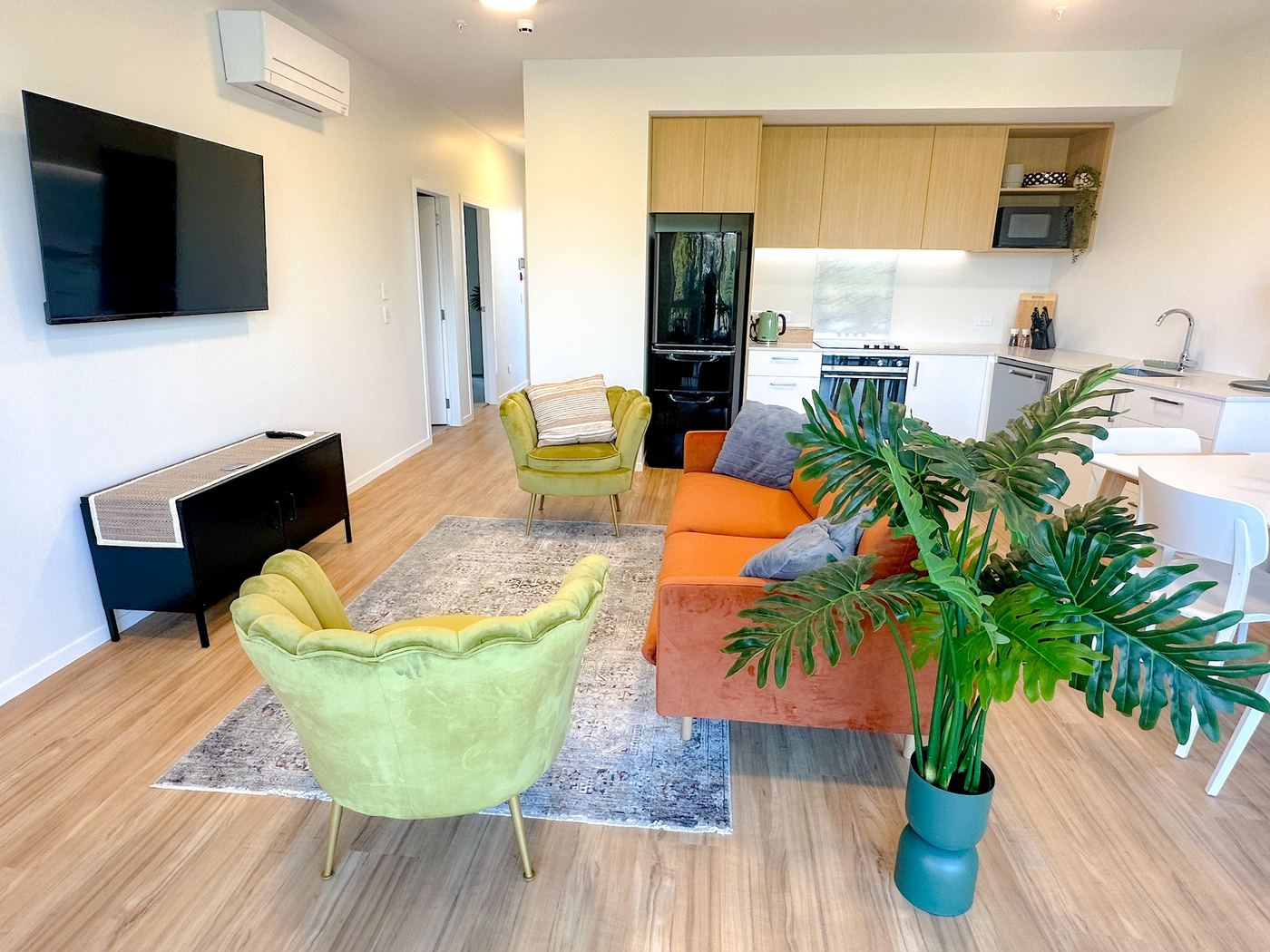 Open-plan living area with wall-mounted TV and kitchen