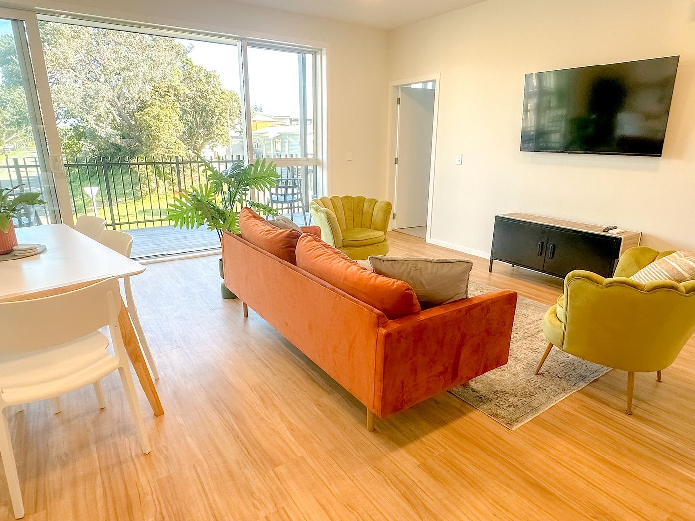 Living room with sofa, armchairs and wall-mounted TV