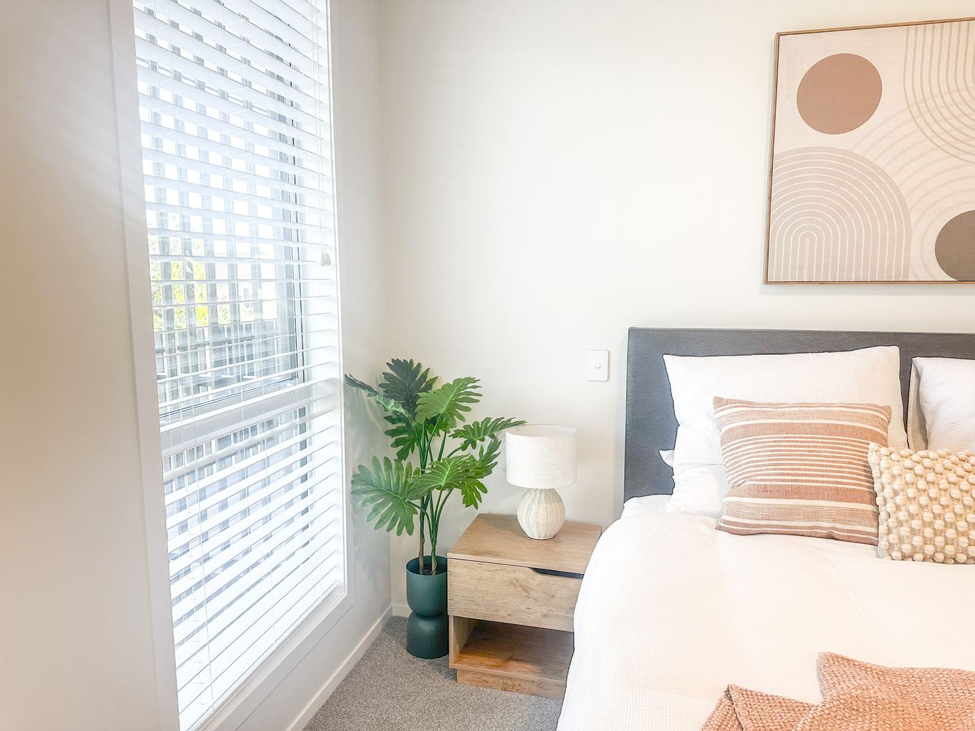 Bedroom corner with bedside table, lamp and plant